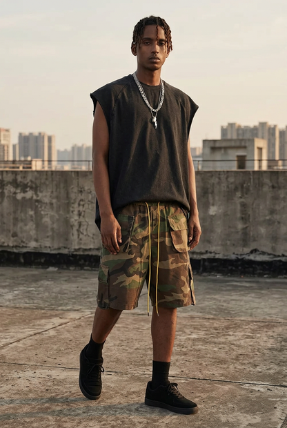 Male model wearing camo cargo shorts with extended yellow drawstrings and the Vintage Black Distressed Tank